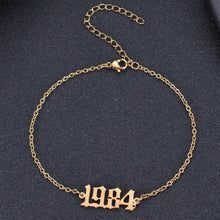Gold personalized birth year anklet featuring a custom year engraved in Old English font.