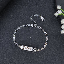 Close-up of Silver lobster claw clasp and Figaro style chain links on personalized name bar bracelet.