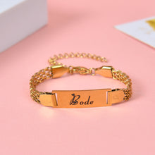 Gold personalized bar bracelet featuring custom script name Mila with heart motif on double strand chain.