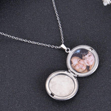 Open silver circle-shaped locket displaying custom inserted portrait photograph on delicate chain.