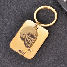 Gold personalized football helmet keychain engraved with a custom name and jersey number.