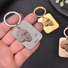 Close-up of a personalized football helmet keychain showing the custom name Abel and number #8.