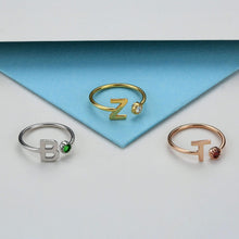 Birthstone prong setting detail on initial ring