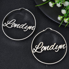 Silver personalized round hoop earrings featuring custom cursive nameplate Londyn laser-cut across the hoop frame.