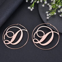 Custom script hoop earrings laid flat on jewelry display