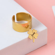Gold custom open band ring featuring a dangling four-leaf clover charm engraved with script name Liam.