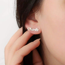 Person wearing gold custom cursive script name stud earring on earlobe for lifestyle scale perspective.