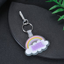 Pastel rainbow acrylic cloud keychain featuring custom purple glitter block text ANGEL with silver snap clasp hardware.