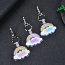 Grouping of pastel rainbow acrylic cloud keychains showcasing custom glitter color text variations and durable hardware.