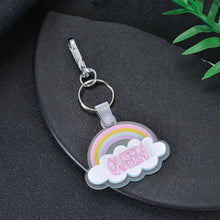 Personalized pastel rainbow cloud keyring customized with pink glitter block lettering QUEEN on white cloud base.