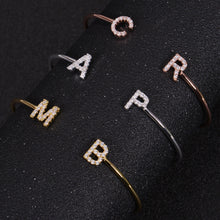 Gold, silver, and rose gold initial bangles shown together