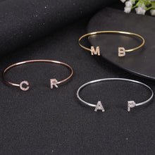 Multiple initial letter bangles laid out together